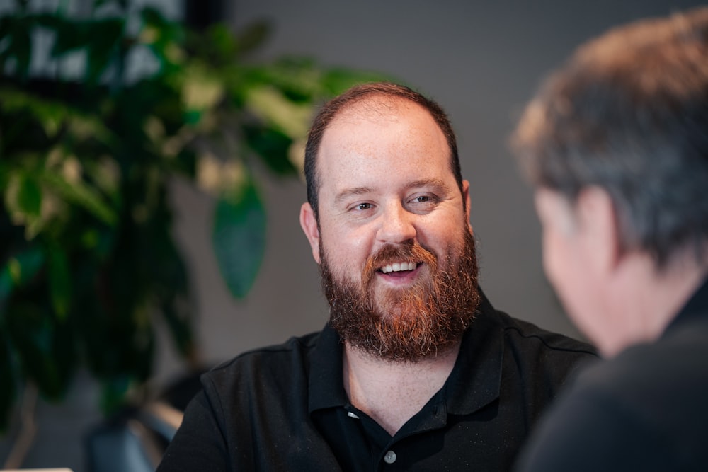 a man with a beard talking to another man