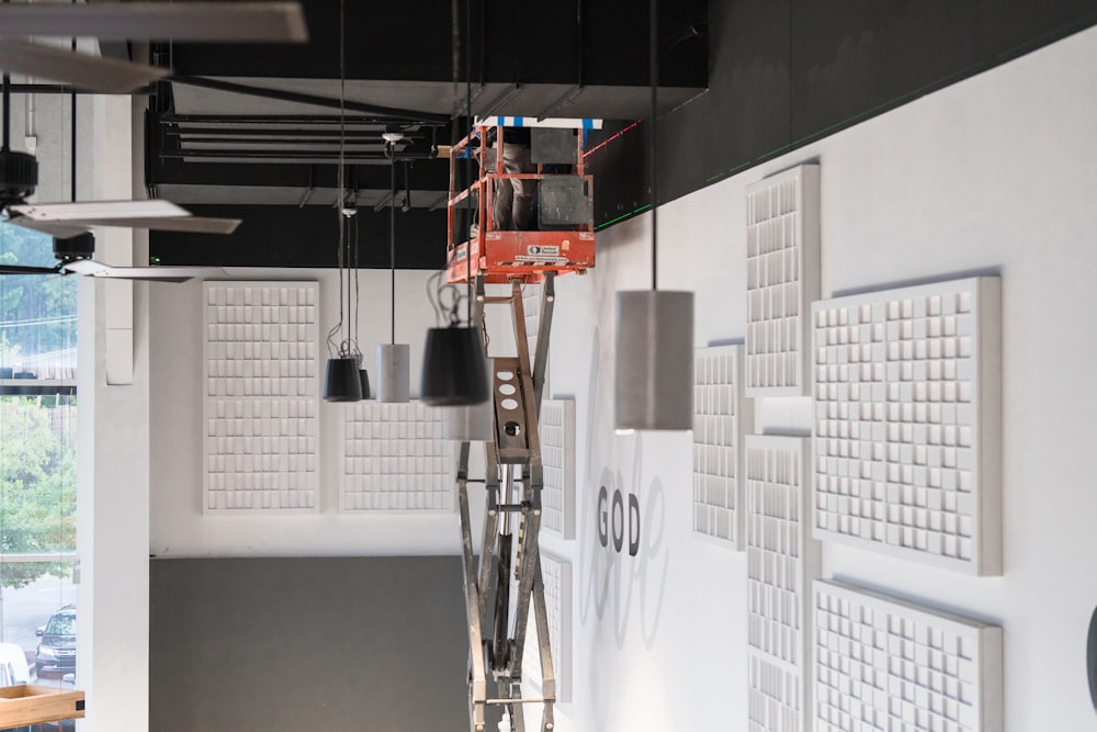 a room with a ladder and some lights hanging from the ceiling