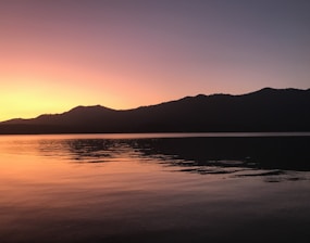 A serene sunset over a calm lake symbolizing peaceful transition.