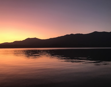 A serene sunset over a calm lake symbolizing peaceful transition.