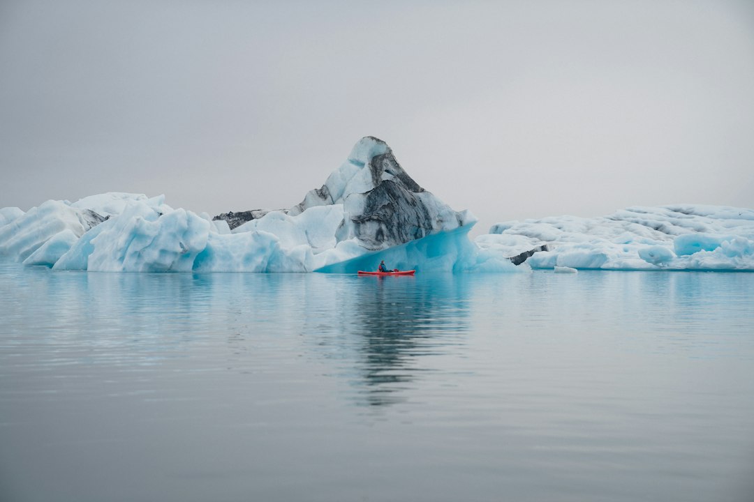 an iceberg in the middle of a body of water, reflections
