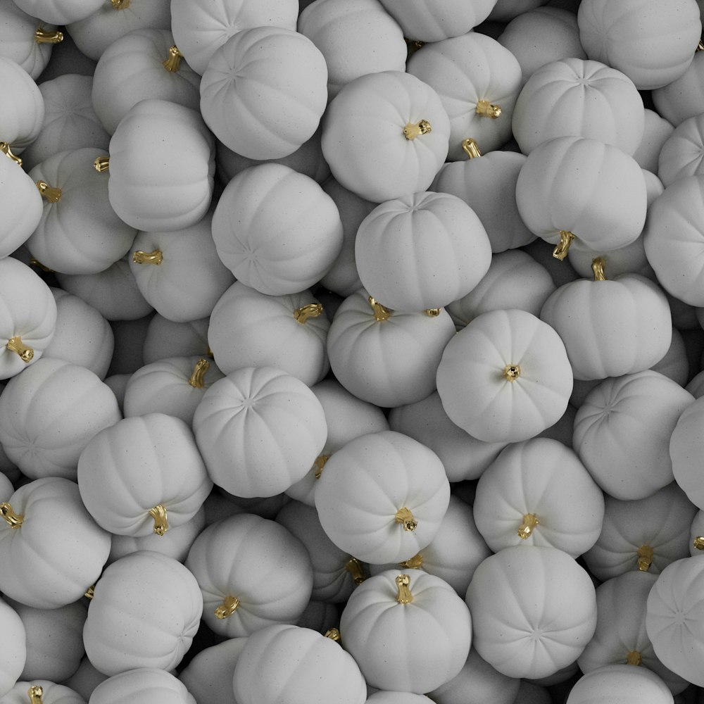 a large group of white pumpkins with gold accents
