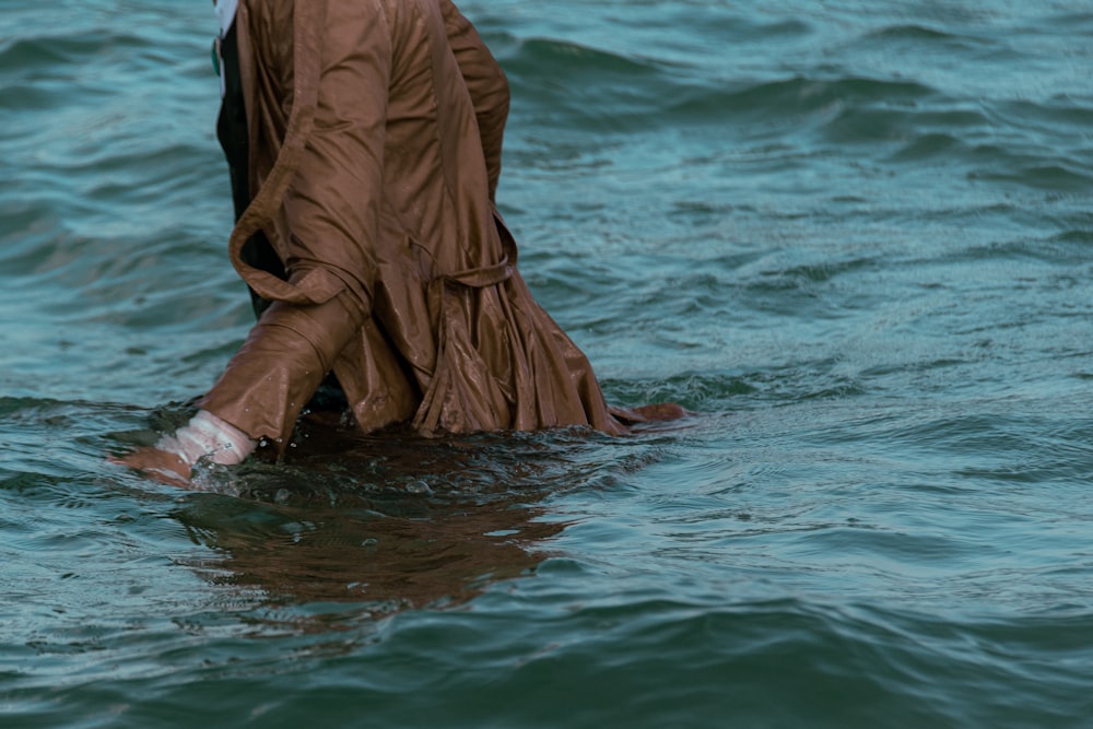 a woman in a brown dress standing in the water