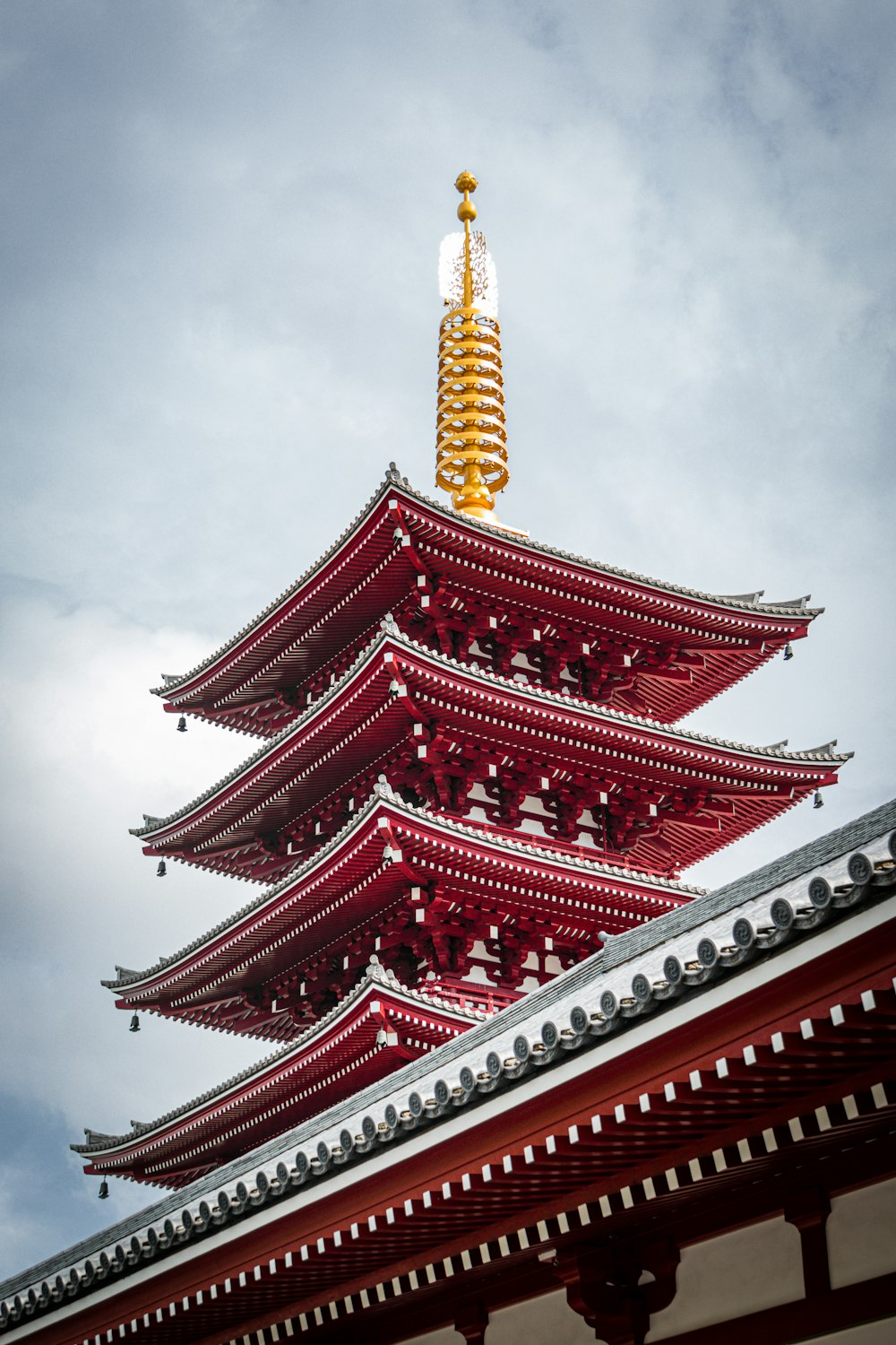 a tall red and white building with a gold roof