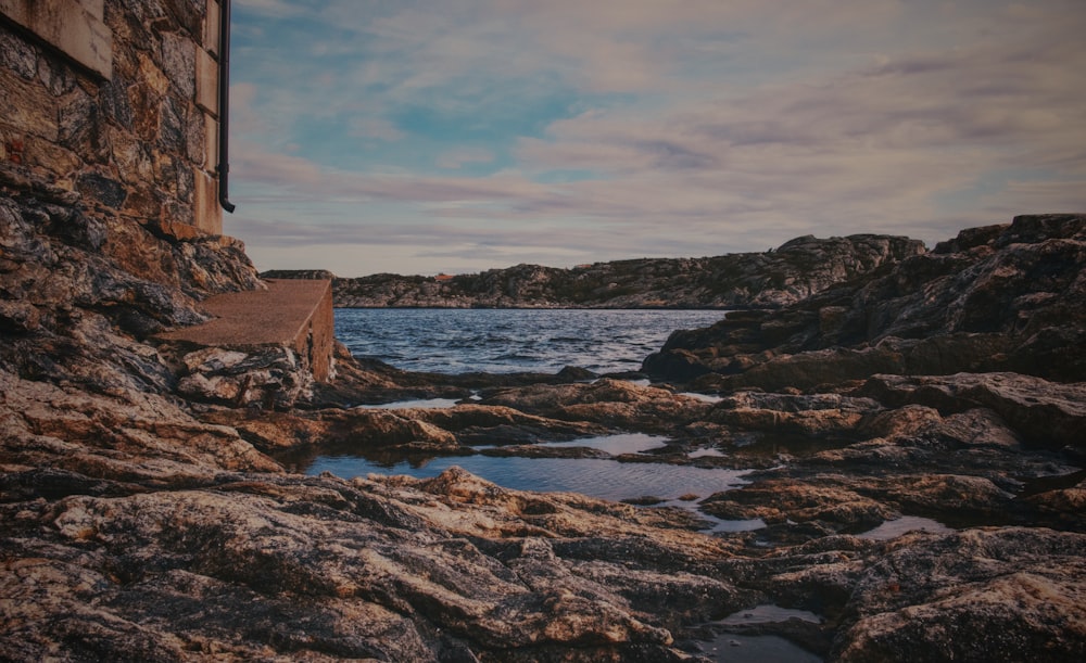 a stone building sitting on top of a rocky shore