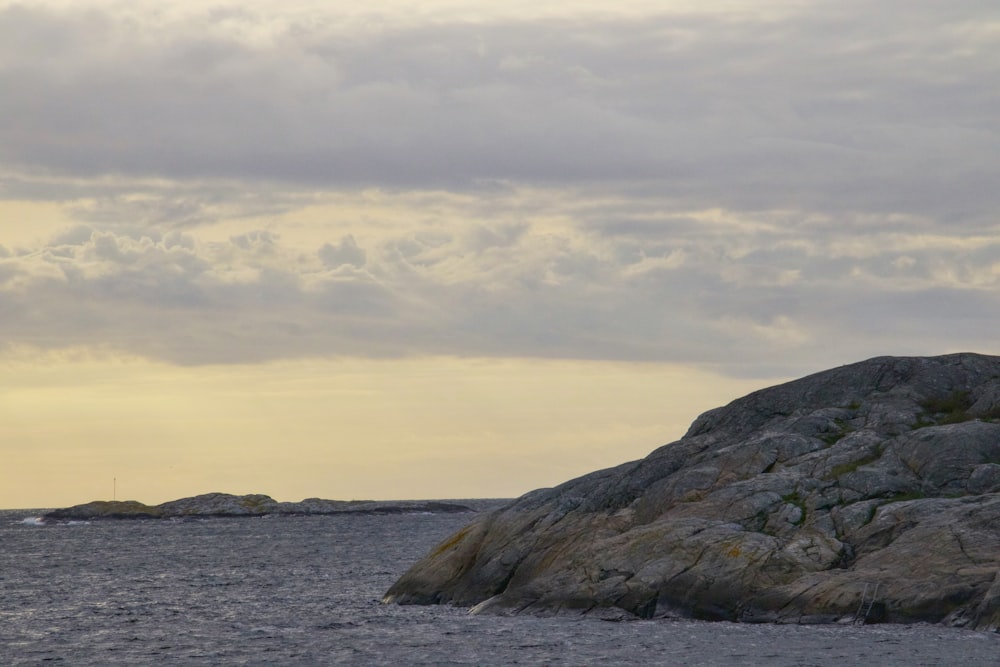 a lighthouse on top of a large rock in the middle of the ocean
