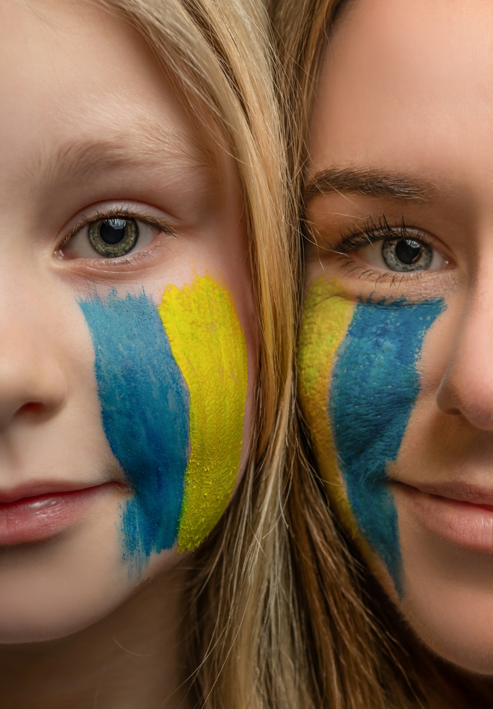 two girls with their faces painted in blue and yellow