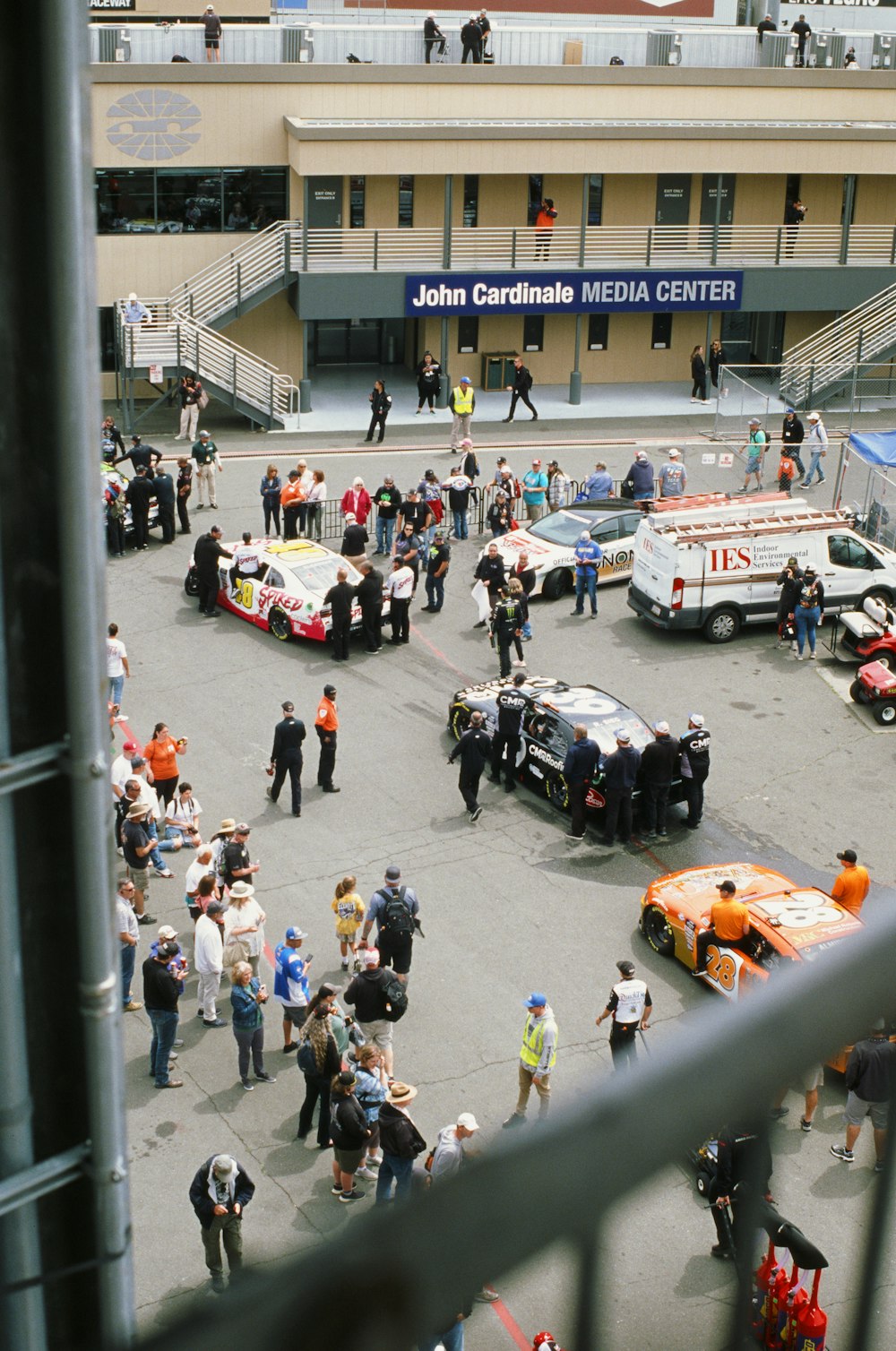 a crowd of people standing around a parking lot