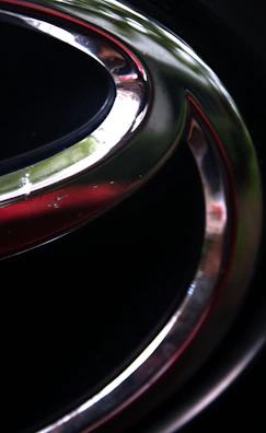 Close-up of a golden-silver gradient emblem resembling the Kabbalistic tree subtly engraved on a dark surface.