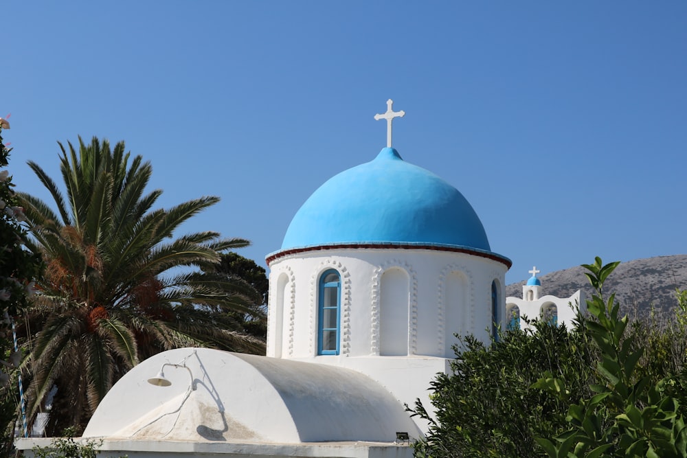 a white and blue church with a cross on top