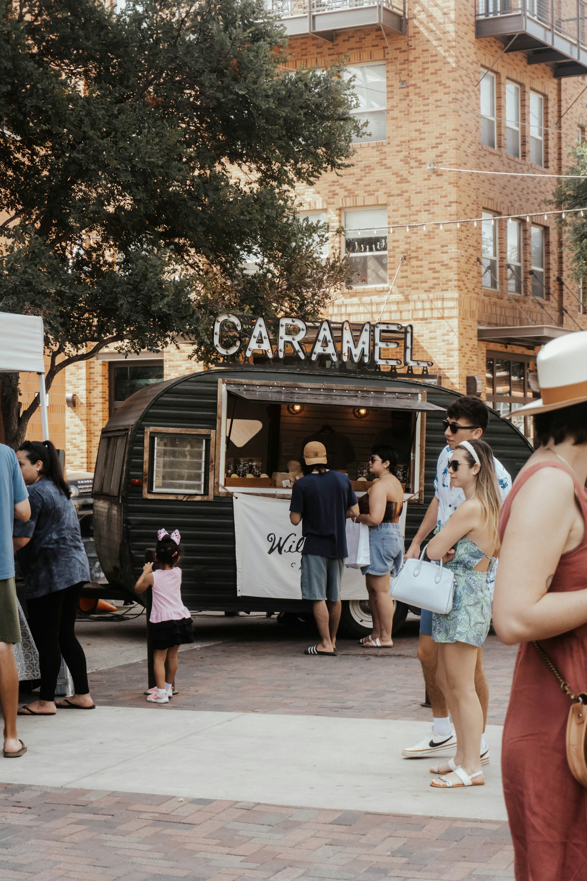 a group of people standing around a food truck