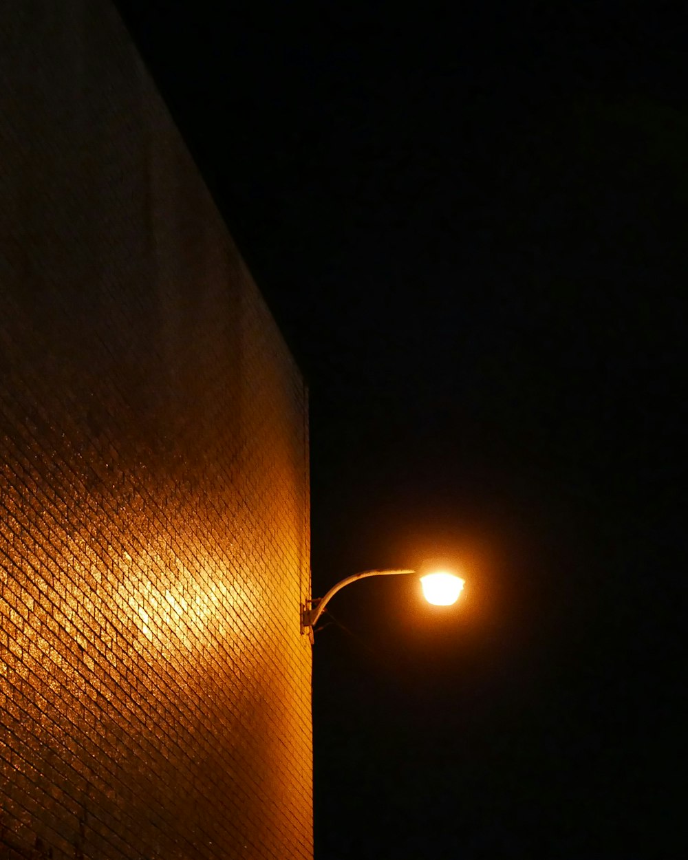 a street light shining on a brick wall