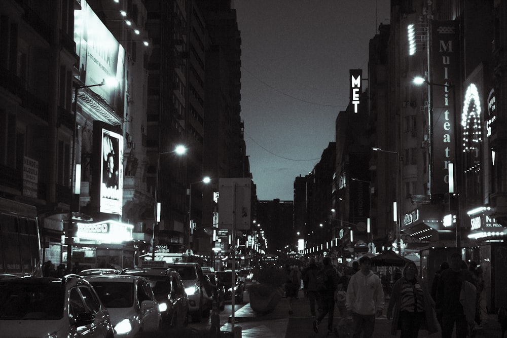 a black and white photo of a city street at night