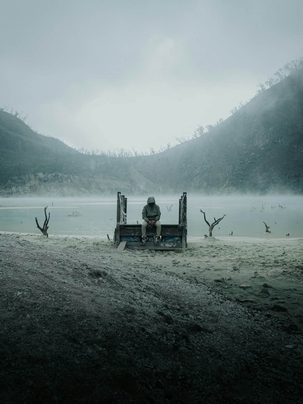 a person sitting on a bench on a beach