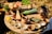 A rustic wooden table displaying fresh dairy products like milk and cheese with herbs.