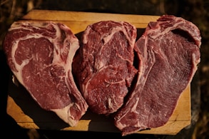 two pieces of steak on a cutting board