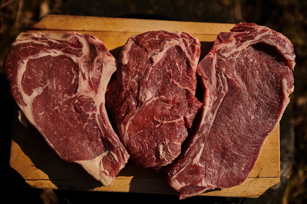 two pieces of steak on a cutting board