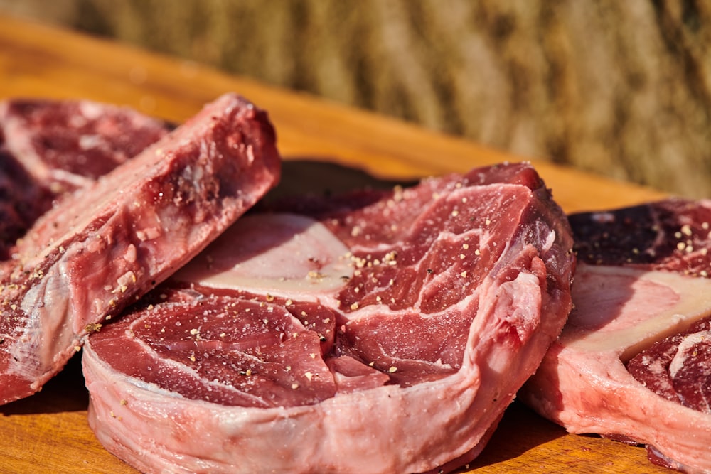 a pile of raw meat sitting on top of a wooden cutting board