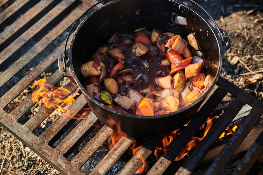 a pot of food is cooking on a grill