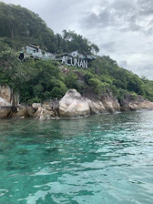 A scenic view of SMAN Satu Atap Nusa Penida campus surrounded by lush hills.