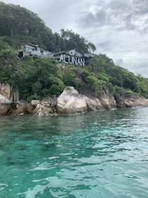 A scenic view of SMAN Satu Atap Nusa Penida campus surrounded by lush hills.
