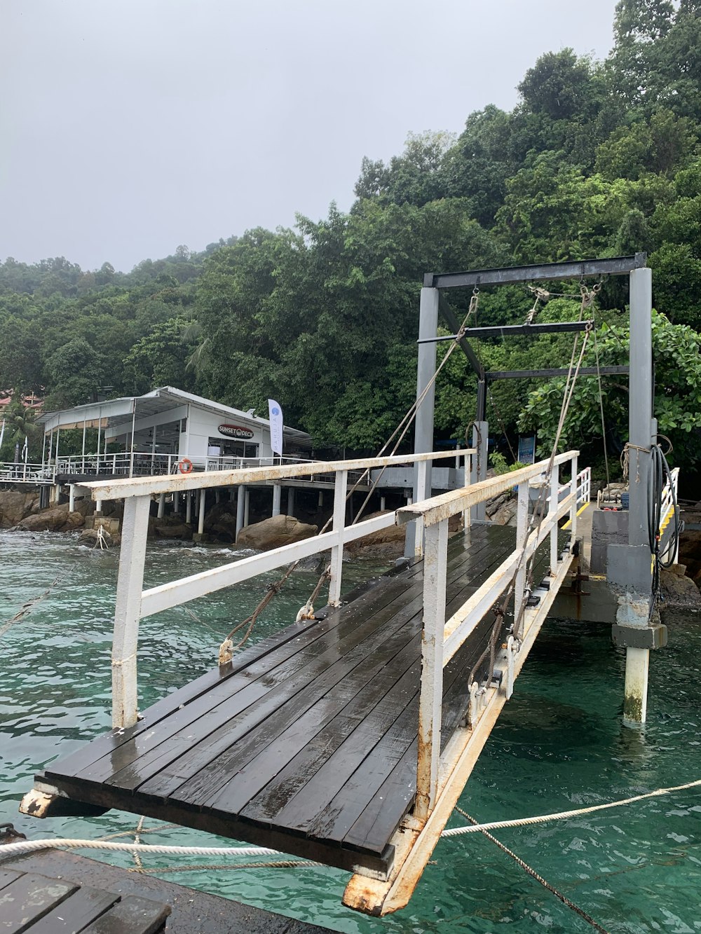 a wooden dock with a house in the background