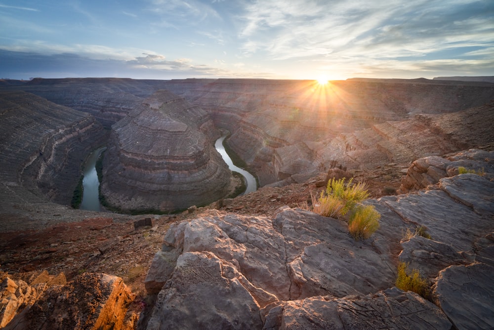 the sun is setting over a canyon with a river running through it