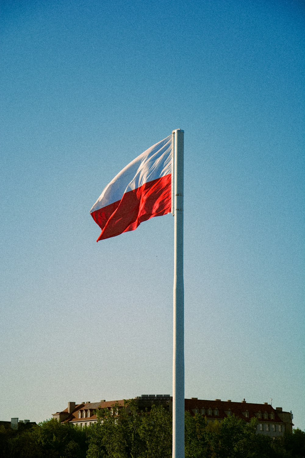 a red and white flag flying in the wind