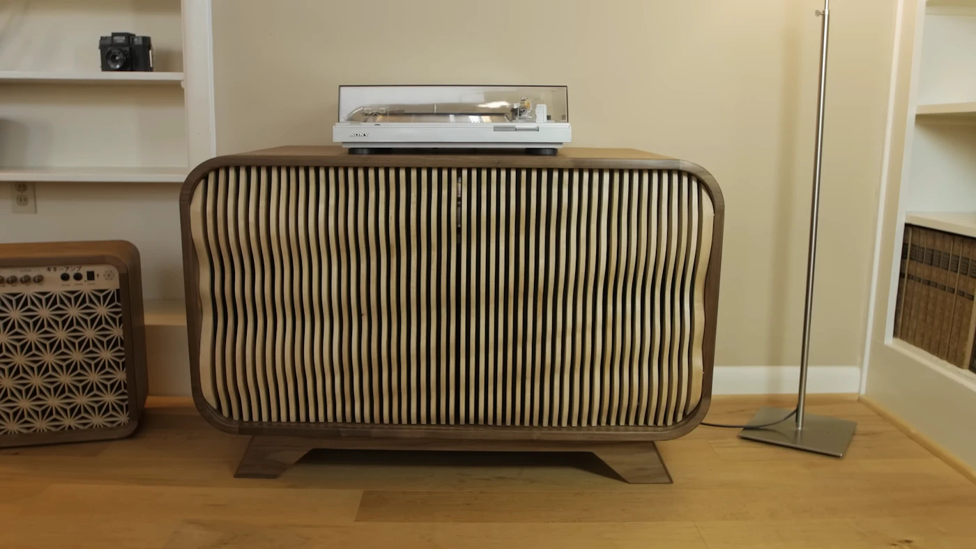 Sideboard aus hellem Holz, darauf ein Plattenspieler, weiches Morgenlicht von links