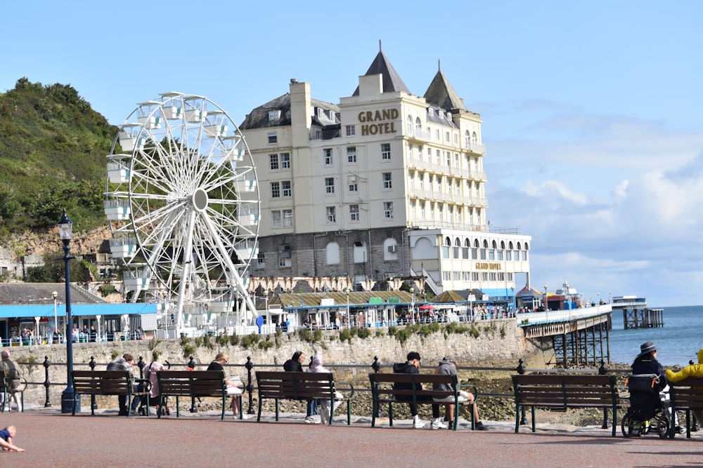 a group of people sitting on benches next to the ocean