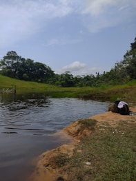 a person laying on the bank of a river
