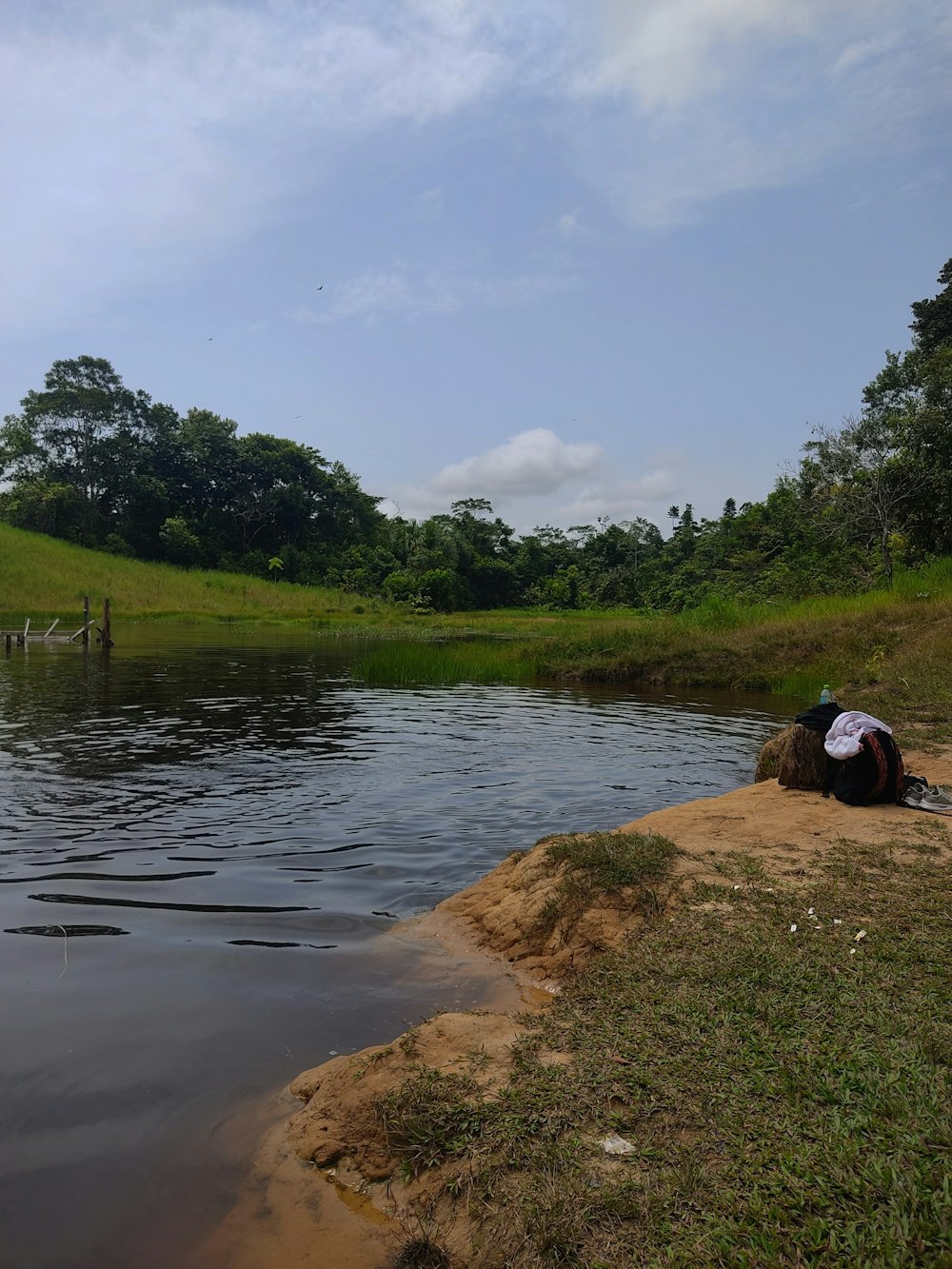 a person laying on the bank of a river