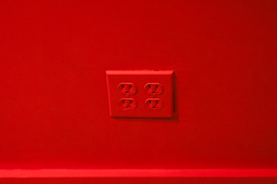 A red wall with a set of four electrical outlets in the center.
