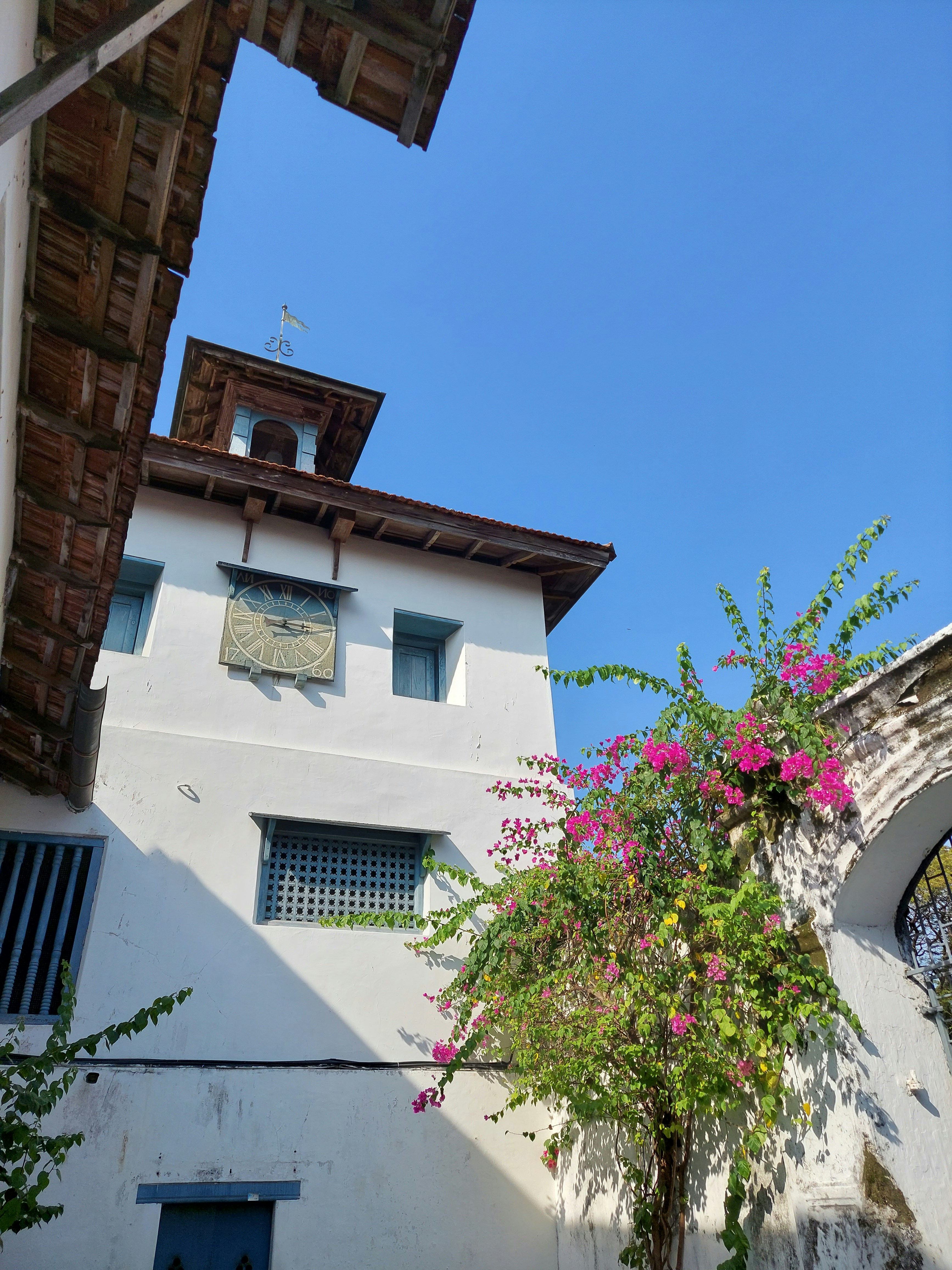 a tall white building with a clock on it's face