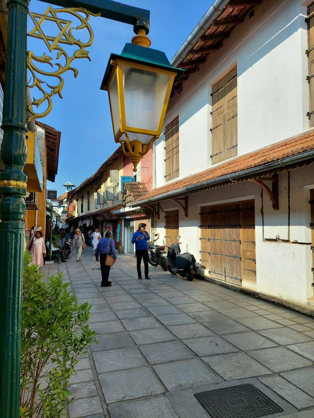 a group of people walking down a street next to tall buildings