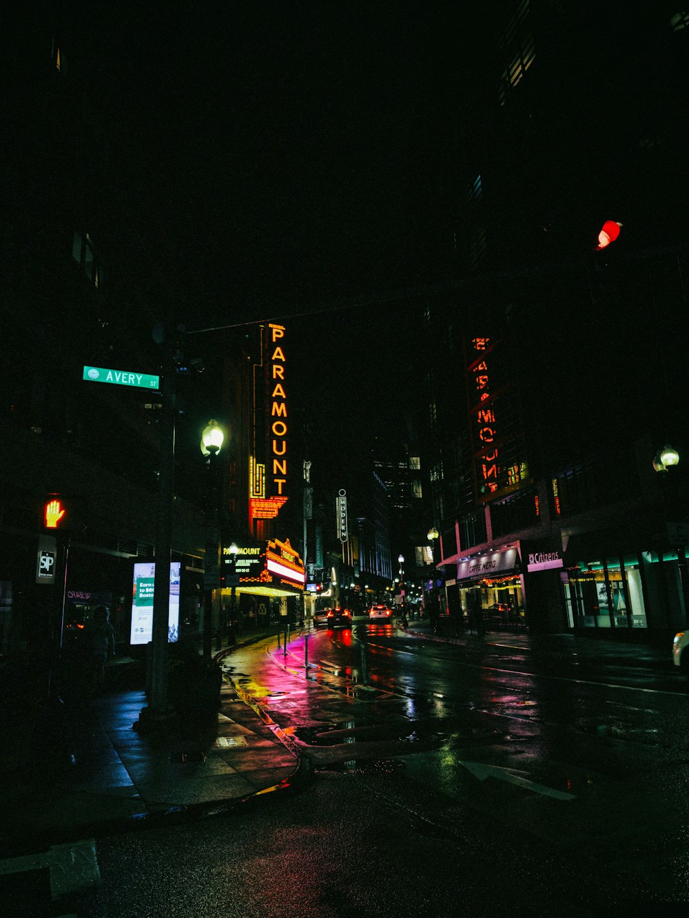 a city street at night with a neon sign