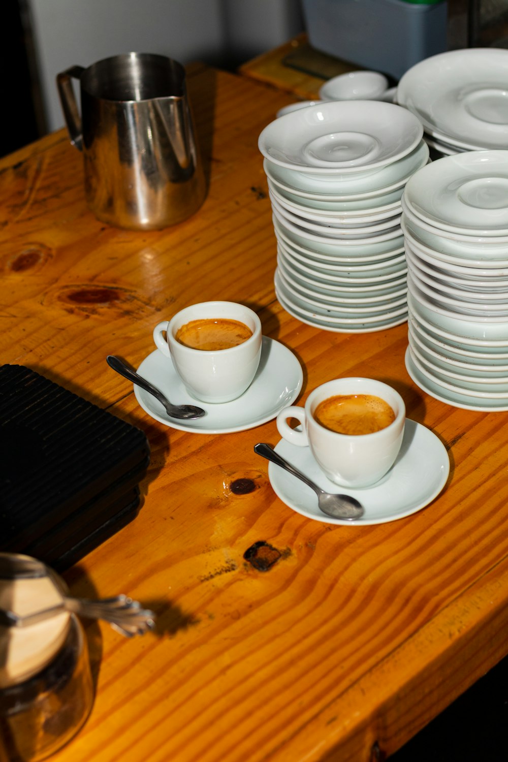 a wooden table topped with plates and cups of coffee