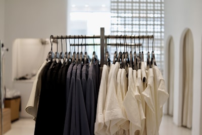 A sleek black and white photo of a modern clothing rack with stylish apparel hanging neatly.