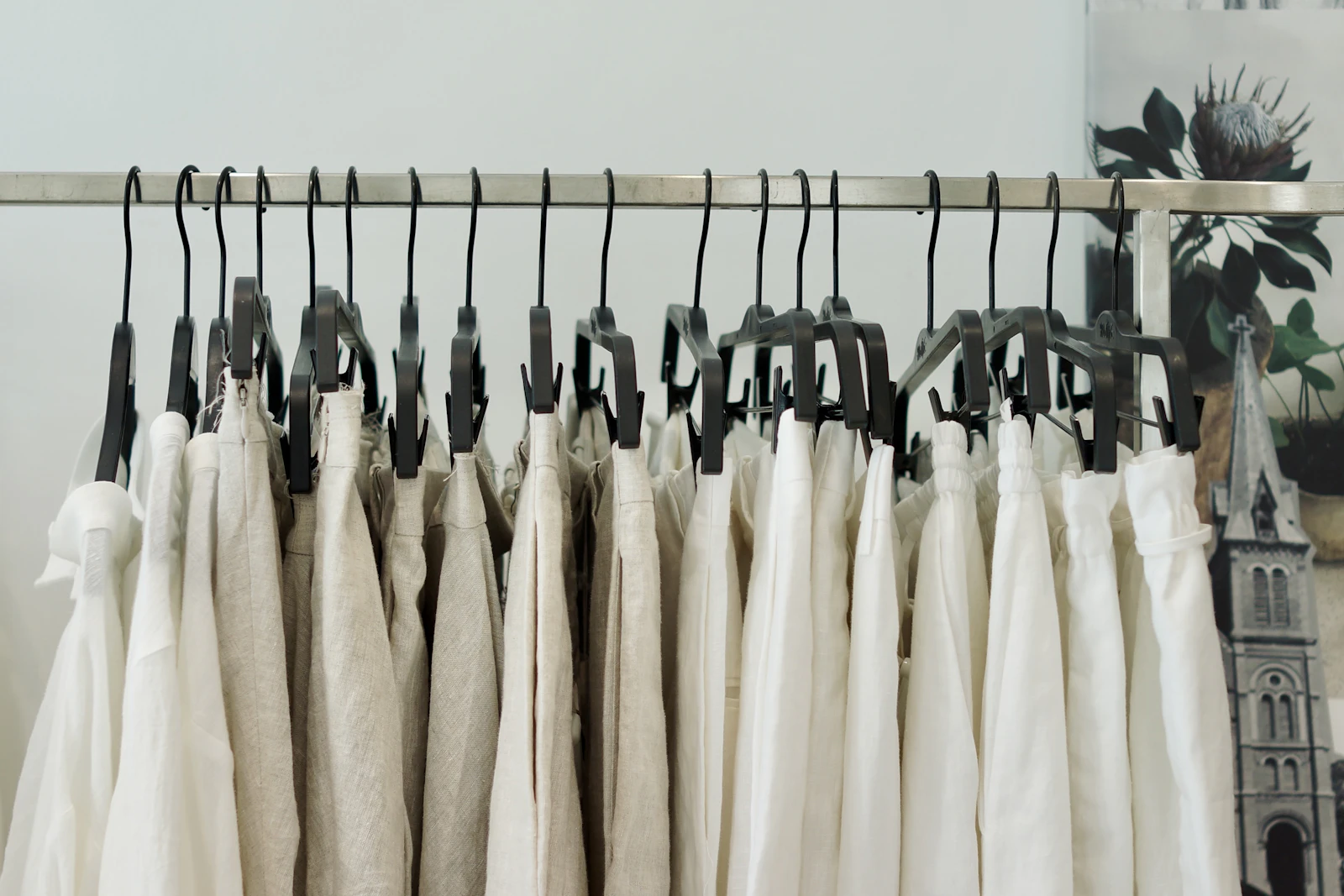 Rail of undyed natural garments on black hangers