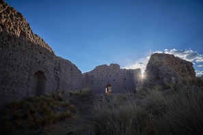 A panoramic view of the ancient ruins near Laas Geel, bathed in golden afternoon light with clear blue skies overhead.