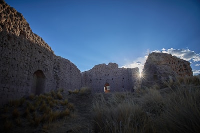 Ancient ruins bathed in golden afternoon light with a clear blue sky