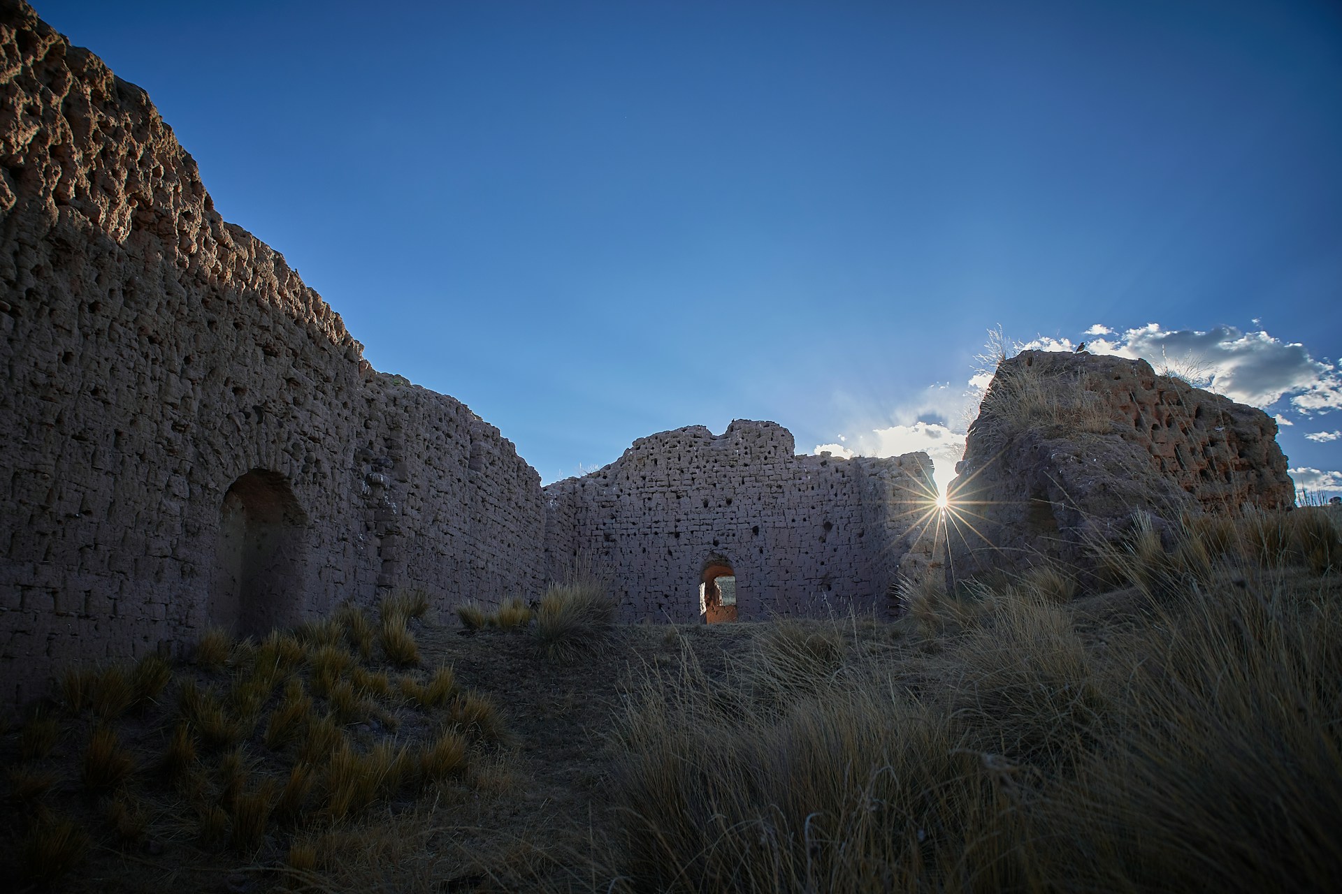 An ancient archaeological site at sunrise, with golden light illuminating weathered stone ruins and whispering stories of the past.