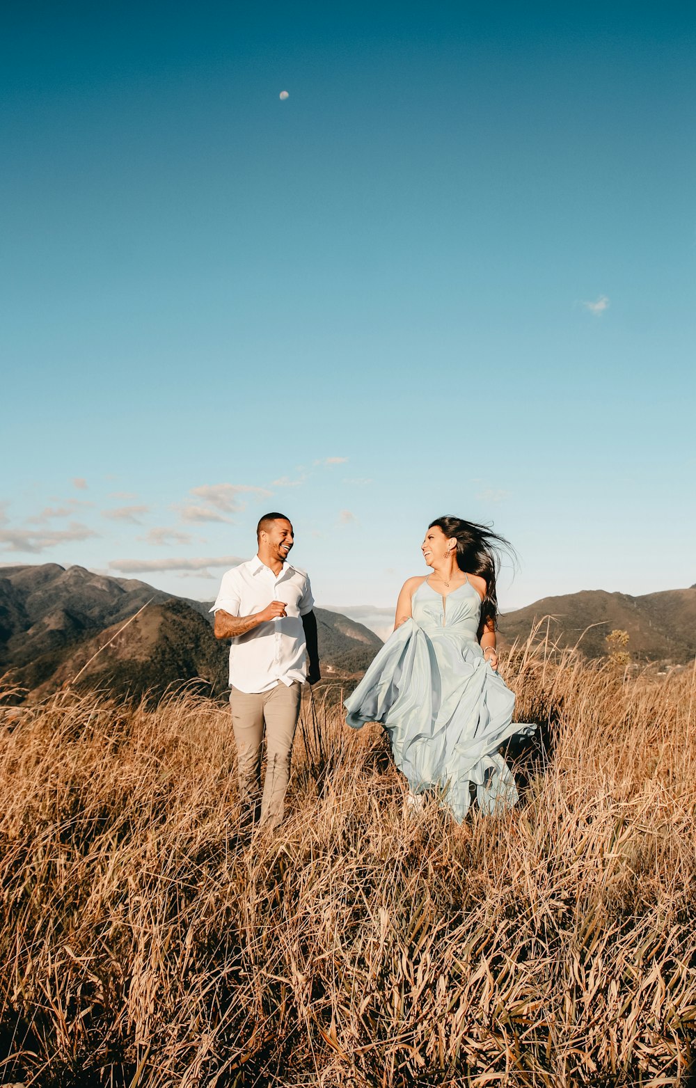 a man and a woman walking through a field