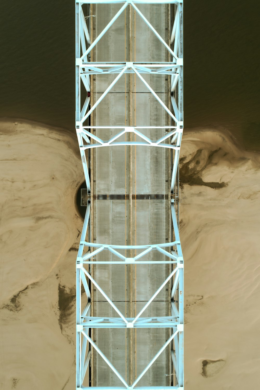 Un alto ponte di metallo su un fiume vicino alla sabbia