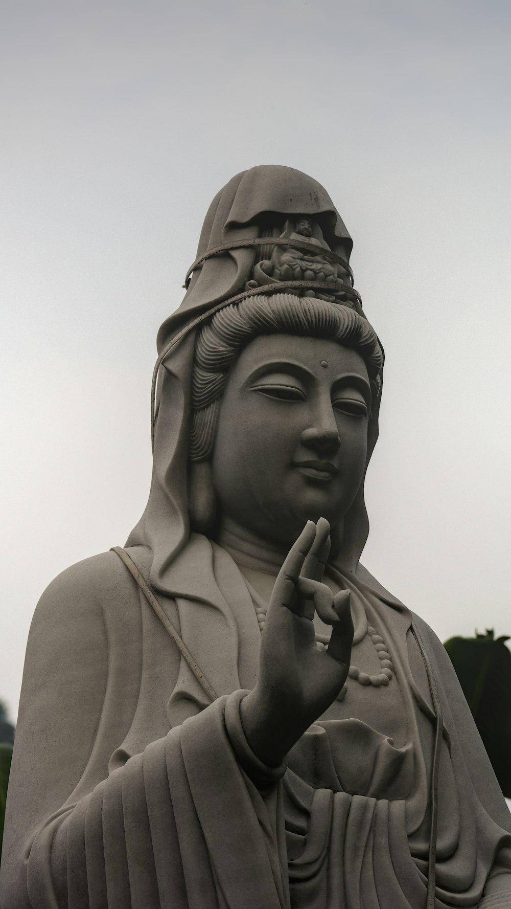 a statue of a buddha holding a peace sign