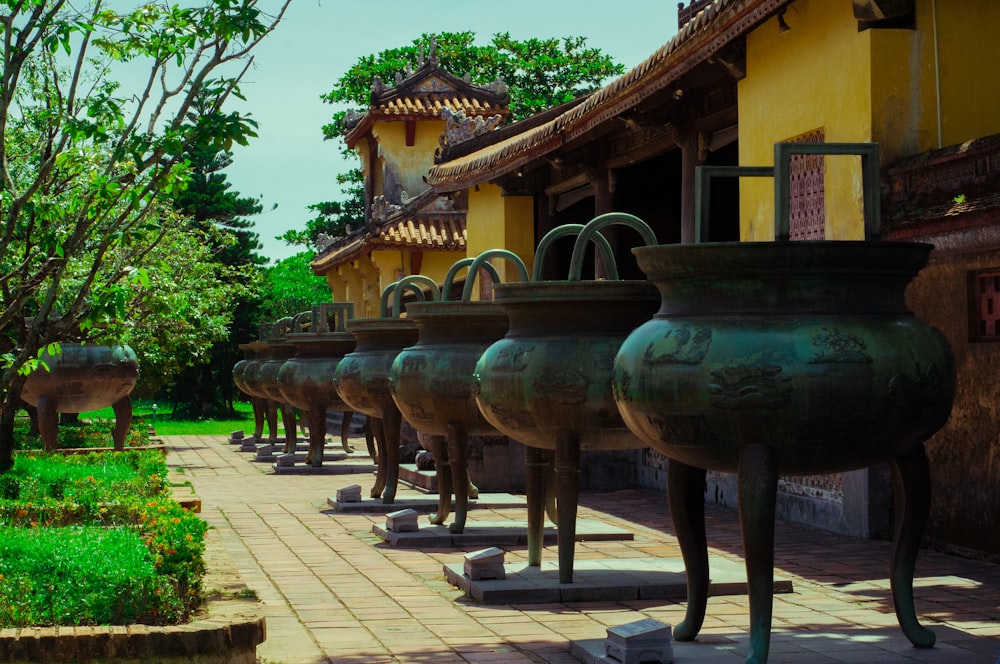 a row of vases sitting next to each other on a sidewalk