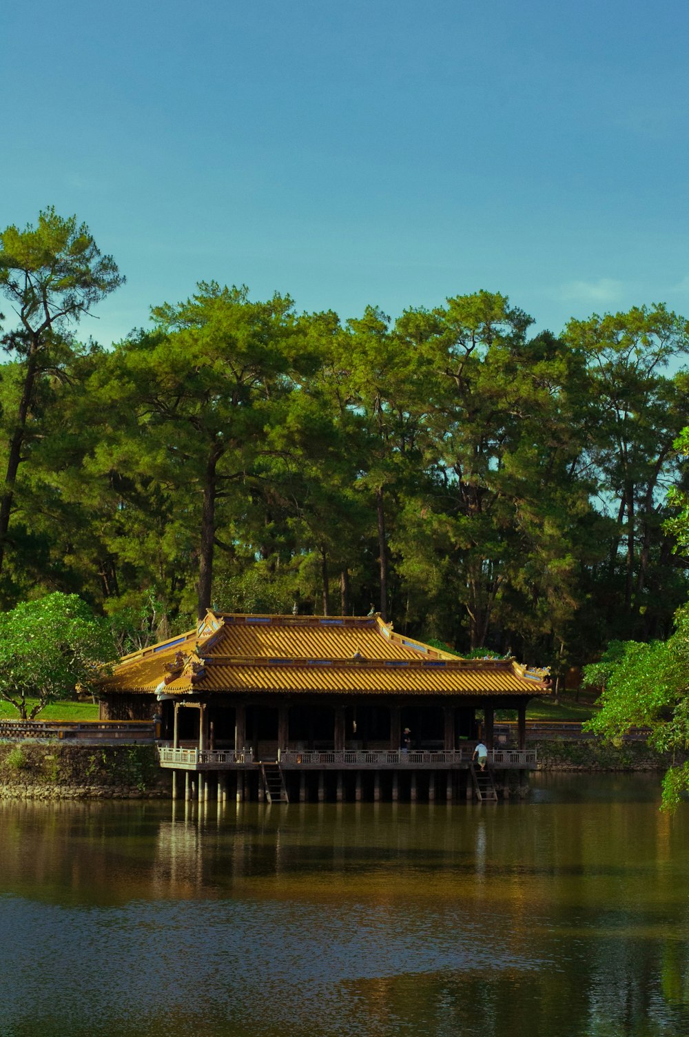 a building sitting on top of a lake next to a forest