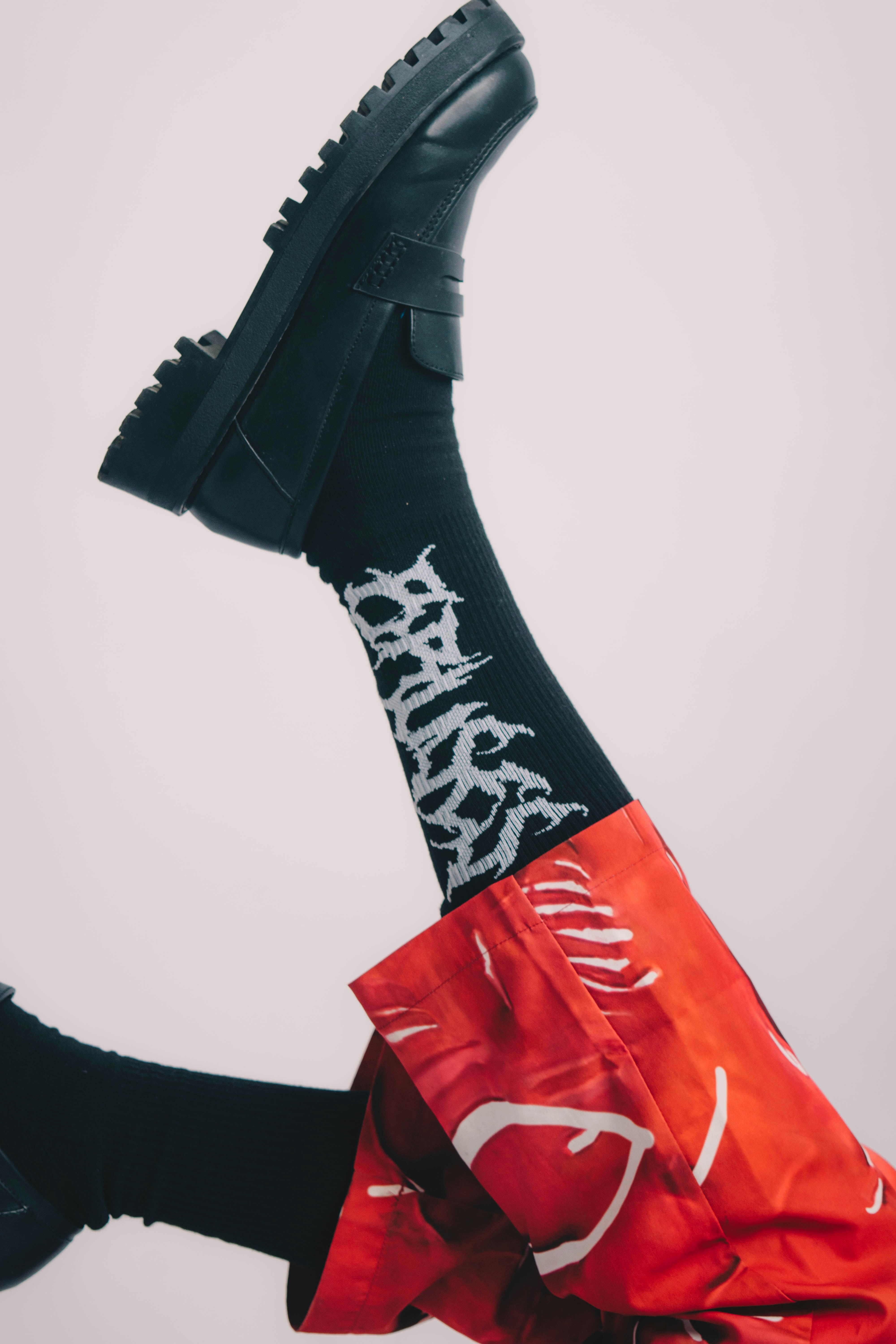 una persona con zapatos negros y una bolsa roja