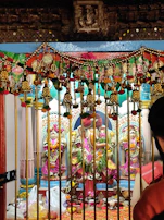 Devotees offering prayers at the Shaktipeetha temple in a colorful festival setting.