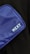 A close-up view of a blue fabric bag with the brand name 'NZXT' printed in white text on it. The bag is positioned against a dark background, showcasing its texture and color.